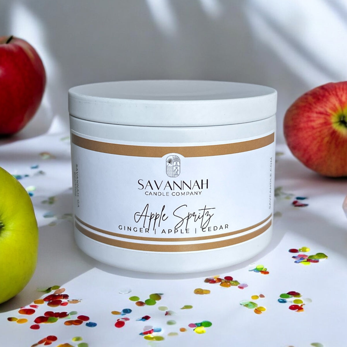 A 6 ounce white candle tin with a label saying Savannah candle company. The fragrance is Apple spritz. Fragrance notes are cinnamon, apple, and cedar.