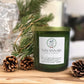 Savannah Candle Company candle with pine branches and pinecones on a wooden surface.  The fragrance is Frasier fir.  Named gin and cypress 