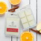 Savannah Candle Company wax melts with oranges and cinnamon sticks on a white wooden surface