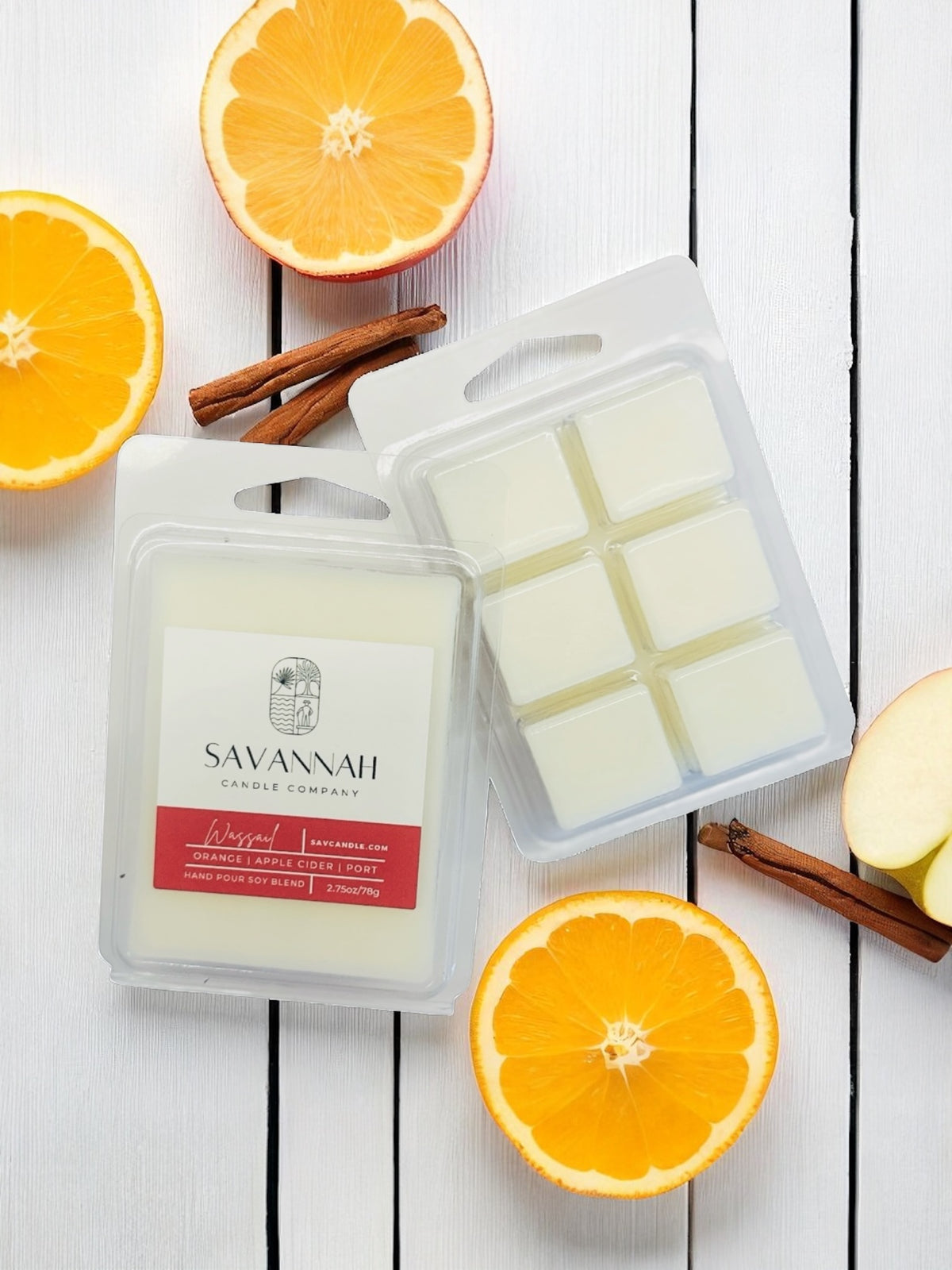 Savannah Candle Company wax melts with oranges and cinnamon sticks on a white wooden surface